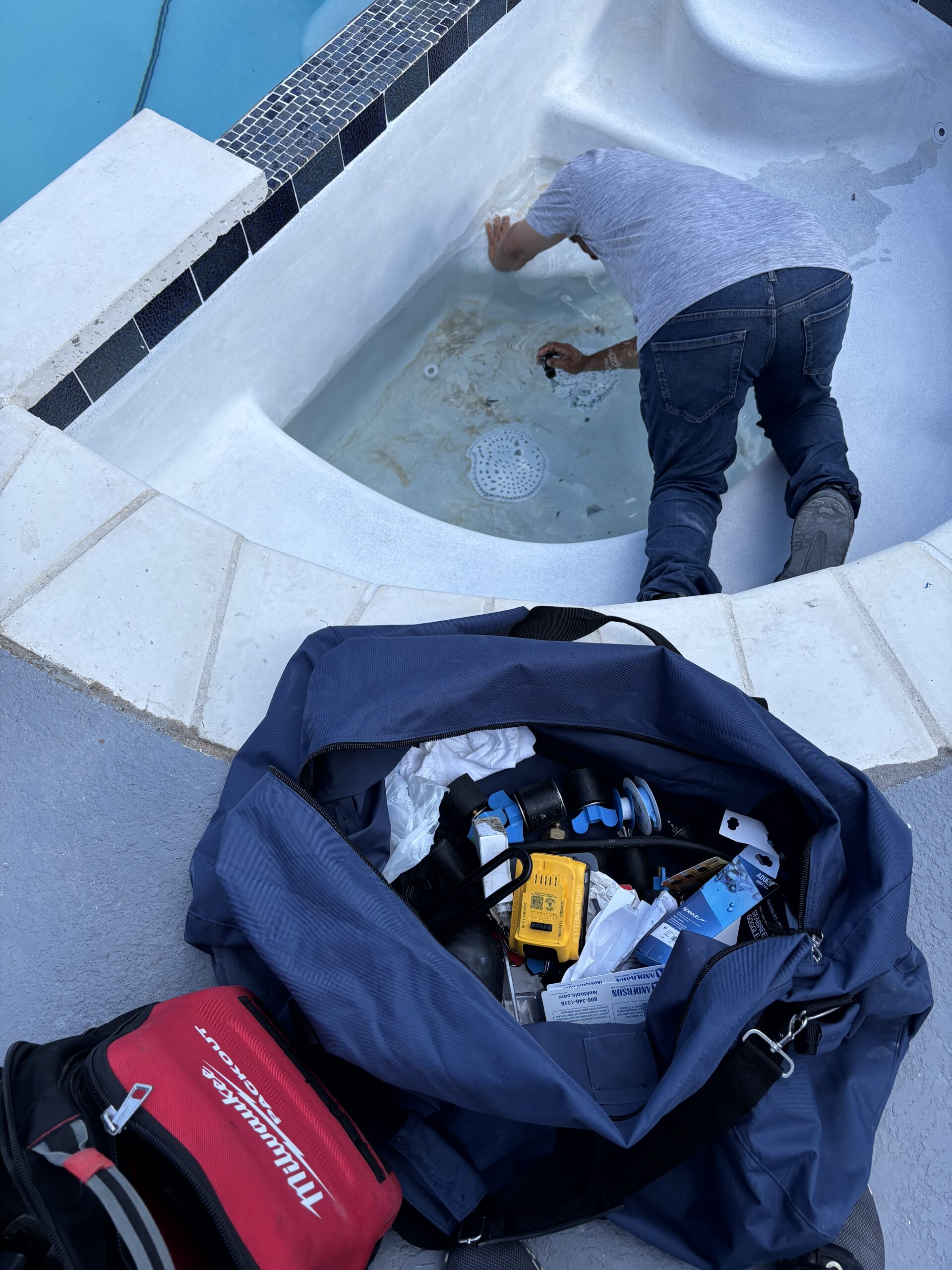 Pool leak detection equipment staged beside an open spa area